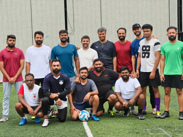 Monks FC players standing and kneeling together on the football turf after a game.